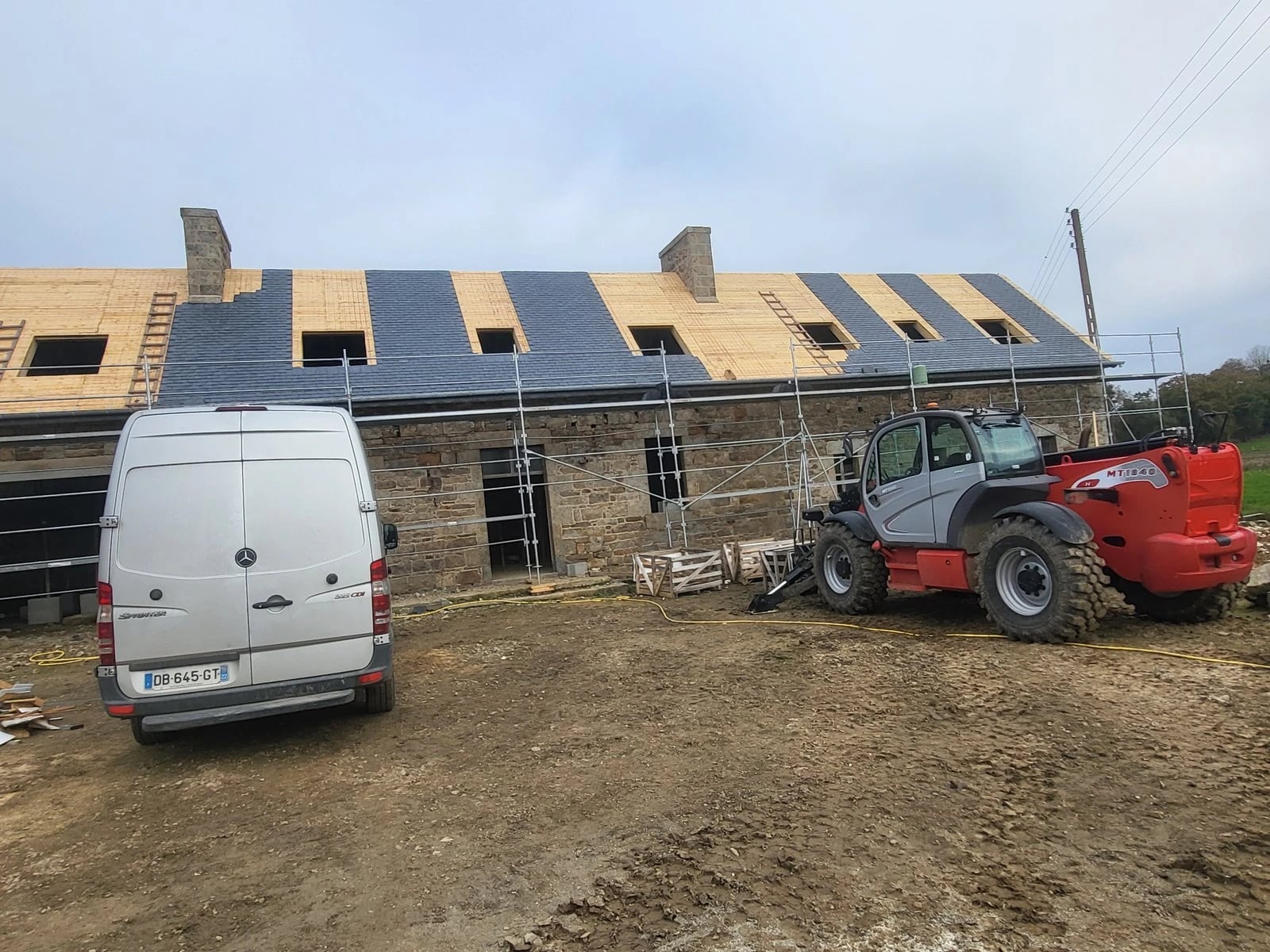 Chantier de pose de fenêtres de toit, utilitaire et chariot élévateur