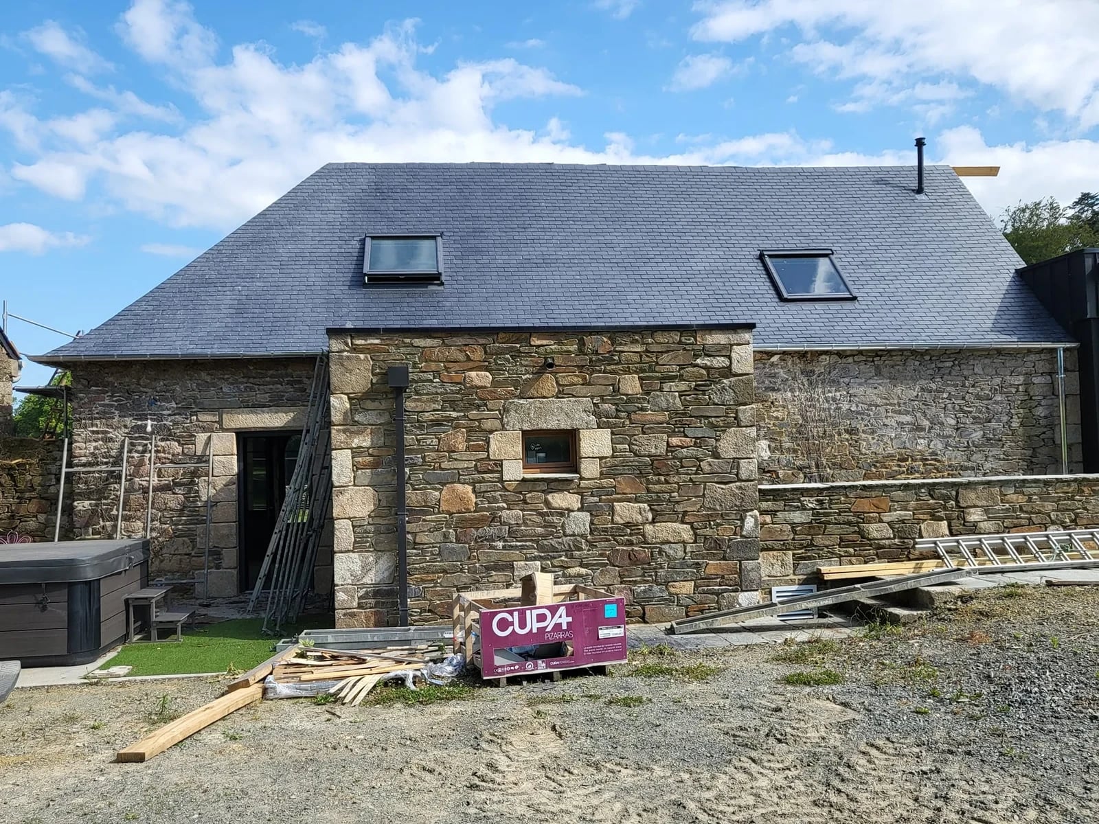 Longère en pierre avec toiture en ardoise neuve et fenêtre de toit